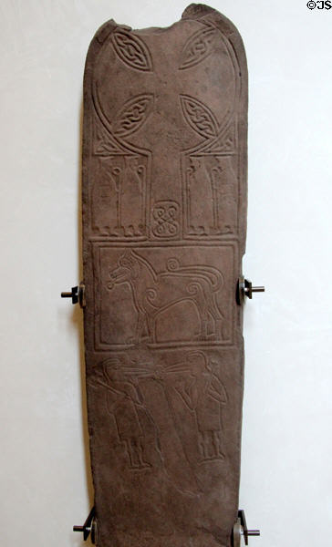 Pictish stone cross & monks with pre-Christian symbolic animal & bird-headed men pecking a human head (700-900) from Papil island at National Museum of Scotland. Edinburgh, Scotland.