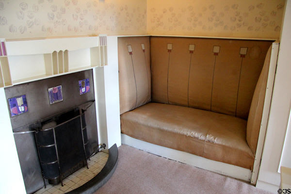 Fireplace with tile squares & built-in settle with thistle motif in main bedroom at Hill House. Helensburgh, Scotland.