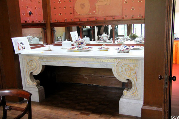 Carved marble sideboard with serving dishes surrounded by mirrors in dining room at Holmwood. Glasgow, Scotland.