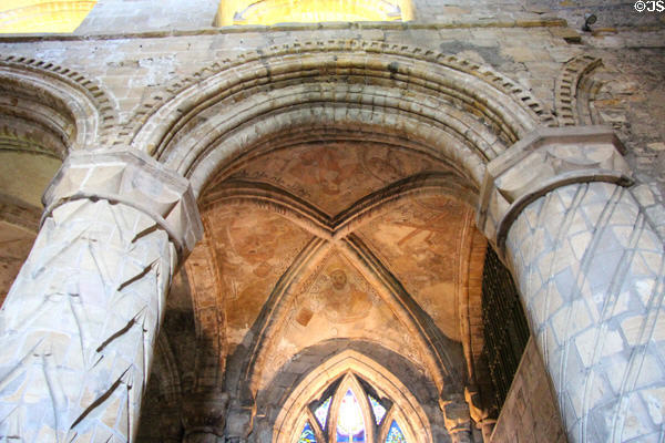 Arch with ancient paintings of saints between carved columns in nave of Dunfermline Abbey. Dunfermline, Scotland.