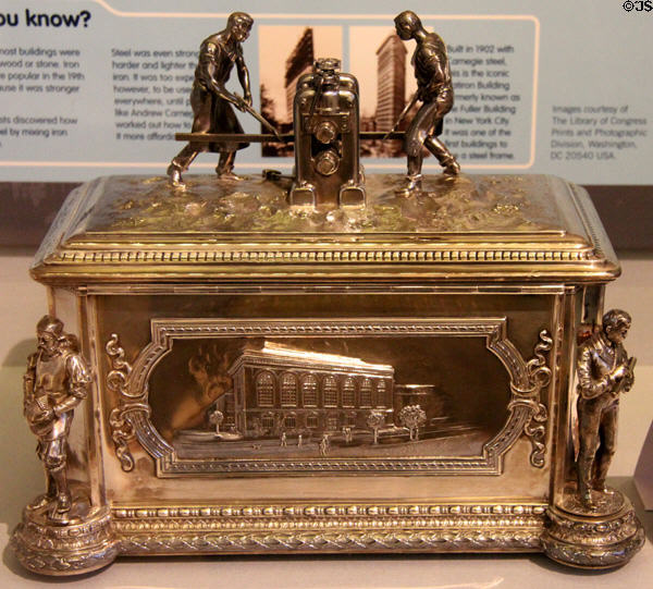 Workers rolling steel railway rails atop casket (1902) by Tiffany & Co. of New York, presented to Carnegie by Stevens Institute of Technology (engraved on front) as thanks for donation at Andrew Carnegie Birthplace Museum. Dunfermline, Scotland.