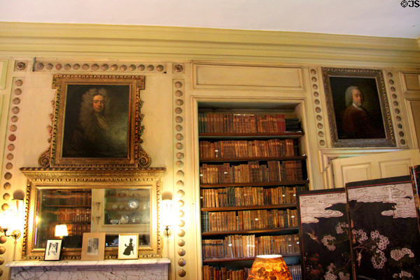Book shelves and ornately framed portraits in Chinese sitting room at Newhailes. Musselburgh, Scotland.