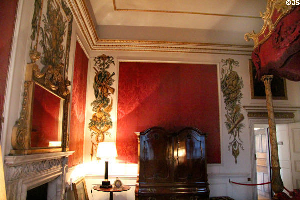 Gilt over mantel mirror & mahogany bedside cupboard both (c1740) attrib. James Cullen surrounded by Rococo-style wall plaques in State Bedchamber at Hopetoun House. Queensferry, Scotland.