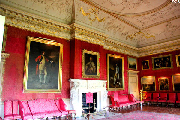French red damask wall coverings by John Dawson covered by collection of paintings in Red Drawing Room at Hopetoun House. Queensferry, Scotland.