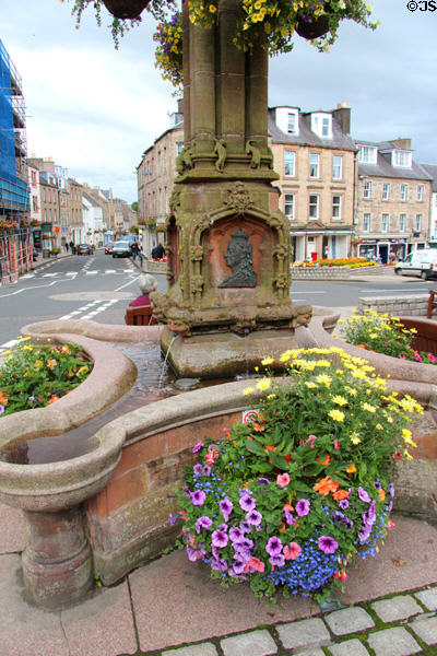 Queen Victoria plaque & flowers at base of Jedburgh Jubilee Fountain (1889). Jedburgh, Scotland.