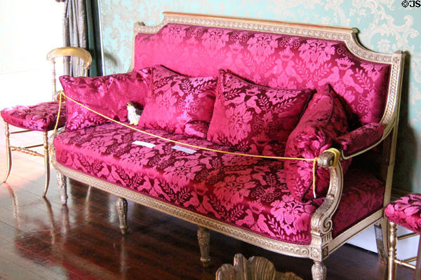 French Empire style red damask sofa in large drawing room at Thirlestane Castle. Scotland.