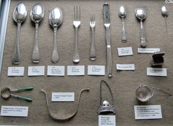 Edinburgh + English silverware & silver objects (1700s) including tongue scrapers (lower left), wine label, tea strainer & nutmeg grater at Traquair House. Scotland.