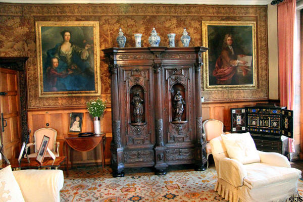 Carved cabinet flanked by portraits in Queen Mother sitting area at Glamis Castle. Angus, Scotland.