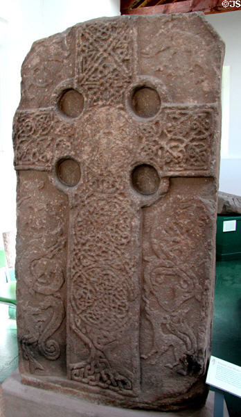 Pictish cross-slab (front of #1) with complete circles at joins of the cross plus lacework of animals in oldest style of Picts at Meigle Sculptured Stone Museum. Meigle, Scotland.