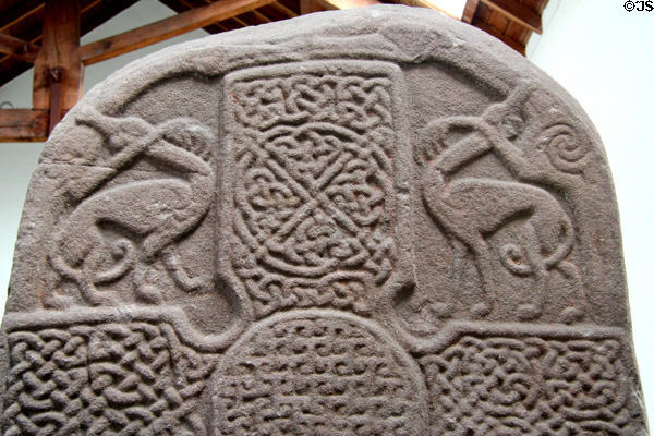 Pictish cross-slab (front of #4) detail of entwined animals with beaks touching above lacey cross at Meigle Sculptured Stone Museum. Meigle, Scotland.
