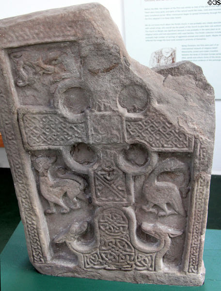 Pictish cross-slab (front of #5) with complete circles in cross corners, lacework & animals with turned heads at Meigle Sculptured Stone Museum. Meigle, Scotland.
