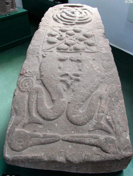Pictish graveslab (#26) with pair of dancing sea-horses & bird heads beak-to-beak beneath array of bosses & coiled snakes at Meigle Sculptured Stone Museum. Meigle, Scotland.