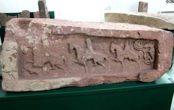 Pictish graveslab (front #11) with 3 riders on prancing horses followed by man with head of beast at Meigle Sculptured Stone Museum. Meigle, Scotland.