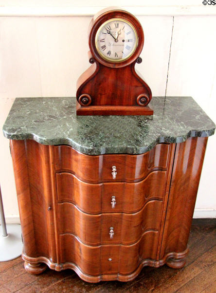 Cabinet with drawers by Robert Lorimer supports mantle clock by John Smith of Pittenweem, Scotland in drawing room at Kellie Castle. Pittenweem, Scotland.