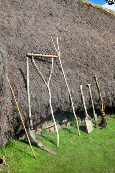 Wooden tools leaning against thatch of Cottar's House in Scottish Township at Highland Folk Museum. Newtonmore, Scotland.