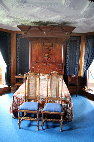 Half canopy bed with Forbes crest on headboard in Blue room at Craigievar Castle. Alford, Scotland.