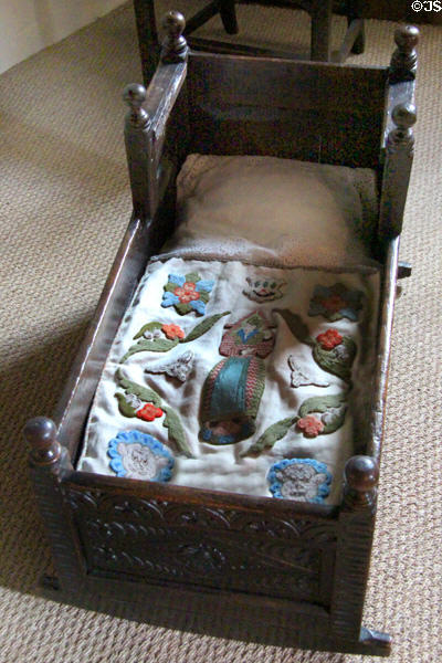 Cradle with embroidered blanket at Crathes Castle. Crathes, Scotland.