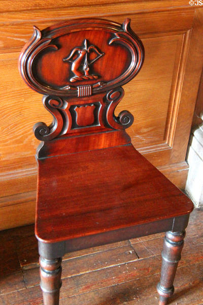 Side chair with scrolled back carved with archer's arm in entrance hall at Haddo House. Methlick, Scotland.