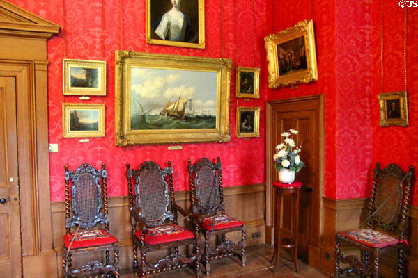 Collection of paintings in red drawing room at Brodie Castle. Brodie, Scotland.