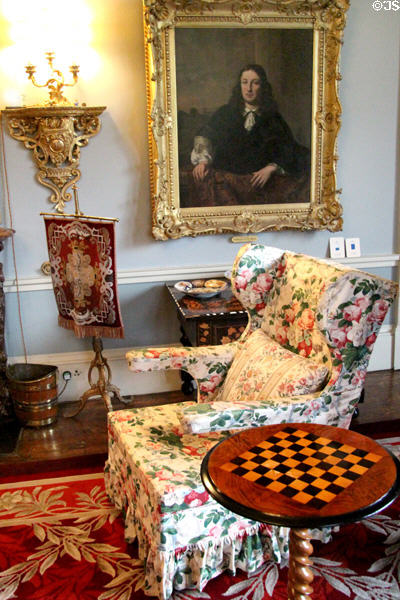 Easy chair & game table in parlor below portrait at Brodie Castle. Brodie, Scotland.