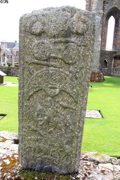 Pictish stone carved (9thC) with horseback riders in hunting scene, double disk & crescent decorated with spirals, all symbols in Pictish art, at Elgin Cathedral. Elgin, Scotland.