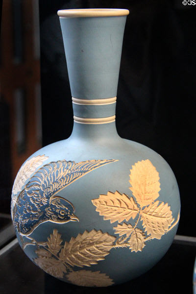 Salopian bottle vase incised with bird & bramble on light bluebackground (c1901-25) by Benthall Pottery at Jackfield Tile Museum. Ironbridge, England.