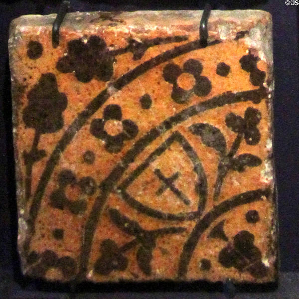 Inlaid clay cross on shield floor tile (15thC) from Abbey in France at Gladstone Pottery Museum. Longton, Stoke, England.