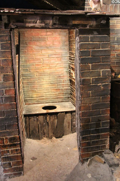 Replica of Medieval outdoor courtyard one-holer toilet in bathroom history gallery at Gladstone Pottery Museum. Longton, Stoke, England.