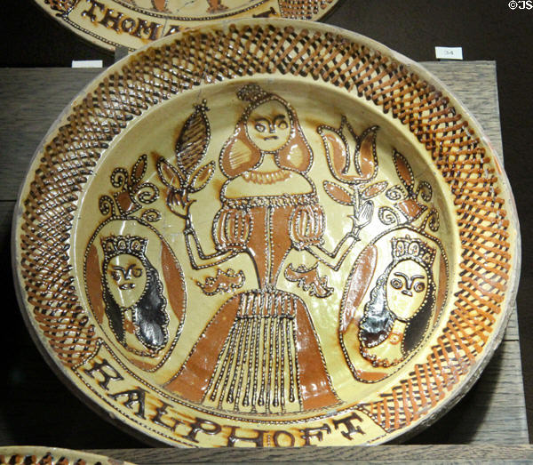 Slip decorated dish prob. showing Princes Mary holding tulip between side portraits of husband William of Orange & father James II (1665-80) by Ralph Toft of North Straffordshire at Potteries Museum & Art Gallery. Hanley, Stoke-on-Trent, England.