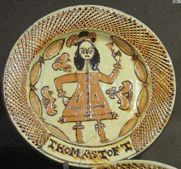 Slip decorated dish showing man in coat & feather hat toasting with wine glass (c1670-80) by Thomas Toft of North Straffordshire at Potteries Museum & Art Gallery. Hanley, Stoke-on-Trent, England.