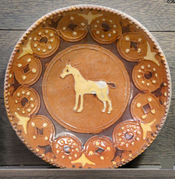 Slip decorated dish with embossed horse (1680-1710) made in North Straffordshire at Potteries Museum & Art Gallery. Hanley, Stoke-on-Trent, England.