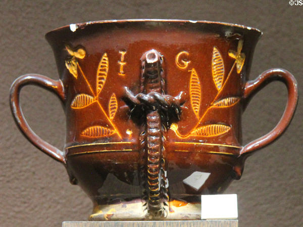 Slip decorated posset pot with scratched design (1723) by potter with initials IG made in North Straffordshire at Potteries Museum & Art Gallery. Hanley, Stoke-on-Trent, England.