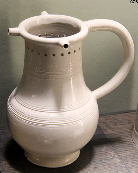 Salt-glazed stoneware puzzle jug (1730-50) made in North Straffordshire at Potteries Museum & Art Gallery. Hanley, Stoke-on-Trent, England.