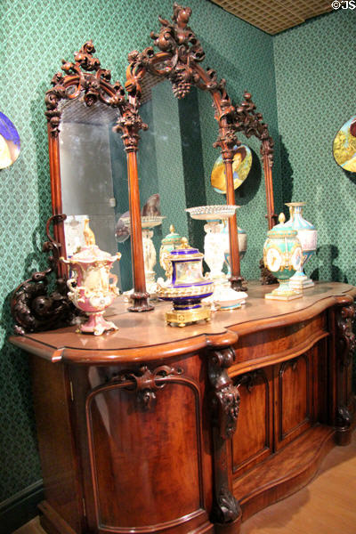 Collection of showpiece Minton of Stoke vases (19thC) on elaborately carved sideboard with mirror at Potteries Museum & Art Gallery. Hanley, Stoke-on-Trent, England.