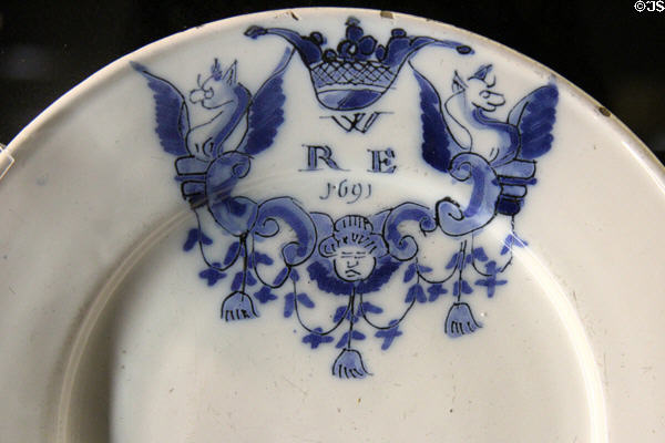 Tin-glazed earthenware plate painted with initials WRE (1691) made in London at Potteries Museum & Art Gallery. Hanley, Stoke-on-Trent, England.