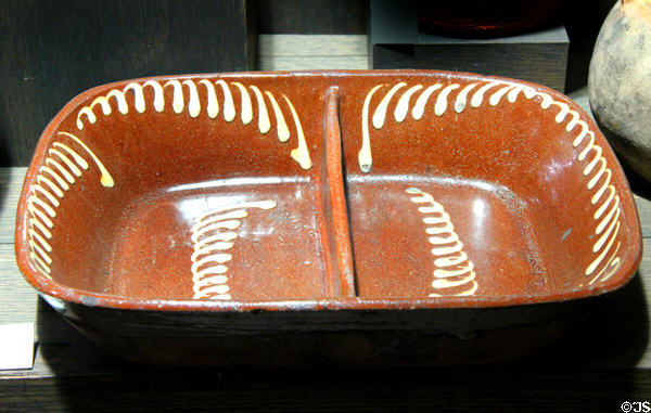 Earthenware dish decorated with white slip (late 19thC) made in Tyne and Wear at Potteries Museum & Art Gallery. Hanley, Stoke-on-Trent, England.