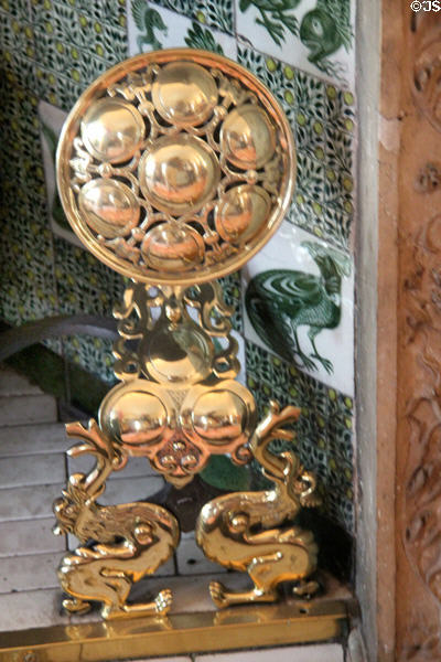 English brass andirons in shape of sunflowers supported by pair of griffins (1880s) in drawing room at Wightwick Manor. Wolverhampton, England.