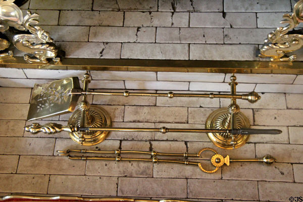 English brass fireplace tongs, shovel, poker & stand (c1880) in drawing room at Wightwick Manor. Wolverhampton, England.