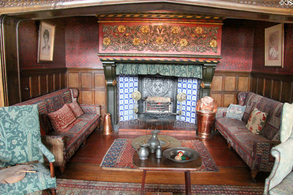 Sitting area around fireplace with Tudor rose panel (1890s) by Charles Eamer Kempe in Great Parlor at Wightwick Manor. Wolverhampton, England.