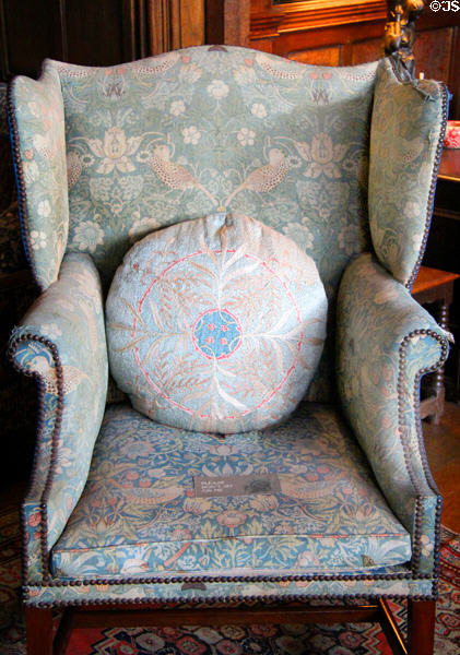 Strawberry Thief fabric on wing-back armchair fixed with brass studs (c1890) by Morris & Co at Wightwick Manor. Wolverhampton, England.