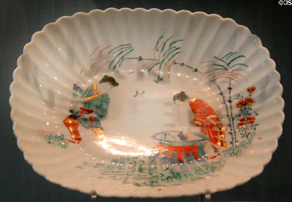 Porcelain fluted dish (1750-2) made in Chelsea, England imitates shape of English silver painted with Japanese 'Hob in the Well' design at Ashmolean Museum. Oxford, England.