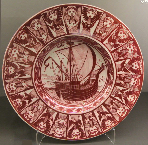 Ruby lustre plate with galleon ringed by symbolic winds (1872-1907) by William De Morgan at Ashmolean Museum. Oxford, England.