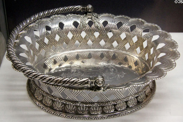 Silver bread basket with engraved arms (1746-7) by Isaac Duke of London at Ashmolean Museum. Oxford, England.