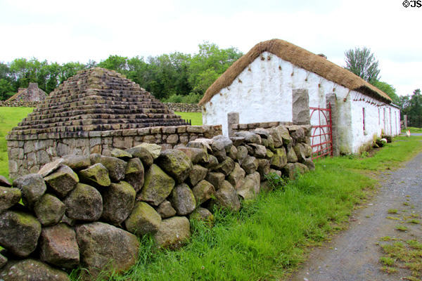 Farm outbuilding with pyramidal stone roof beside thatched Ballyveaghmore farm house (1840s) at Ulster Folk Park. Belfast, Northern Ireland.