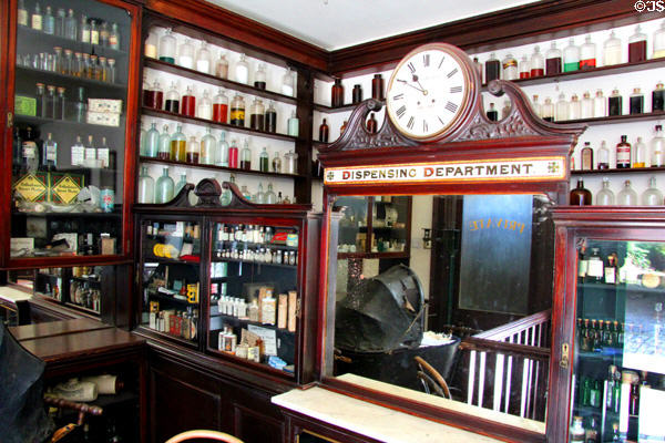 Pharmacy dispensing department with clock in J Hill Chemist shop at Ulster American Folk Park. Omagh, Northern Ireland.