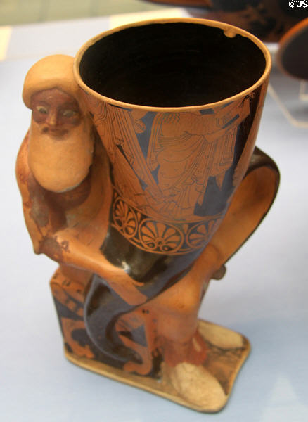 Terracotta red figure rhyton in form of Dionysus holding drinking cup (500-490 BCE) made in Athens at British Museum. London, United Kingdom.