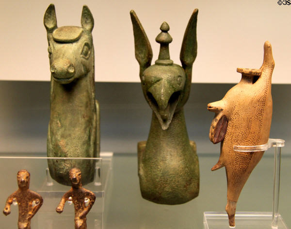 Etruscan bronze carriage shaft ends shaped as horse & griffin (600-550 BCE) from Chiusi plus dead-hare perfume bottle (600-550 BCE) from Nola, Campania at British Museum. London, United Kingdom.