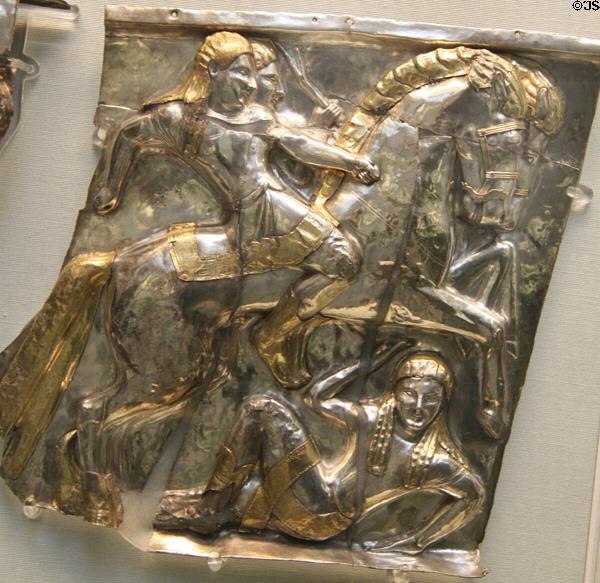 Etruscan silver with electrum relief panel of horse-racing riders with fallen comrade underfoot perhaps from parade chariot or furniture (540-520 BCE) from Castel San Mariano, Italy at British Museum. London, United Kingdom.