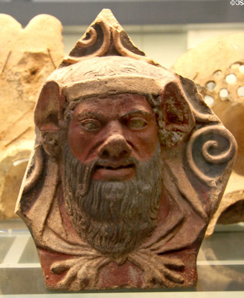 Etruscan painted terracotta antefix molded with head of man with beard (400-300 BCE) from Italy at British Museum. London, United Kingdom.