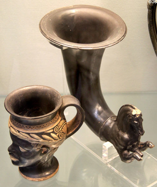 Etruscan mug in shape of African Boy (head-kantharos) (c325-275 BCE) & Etruscan black glazed rhyton in form of galloping horse (300-200 BCE) from Vulci, Italy at British Museum. London, United Kingdom.
